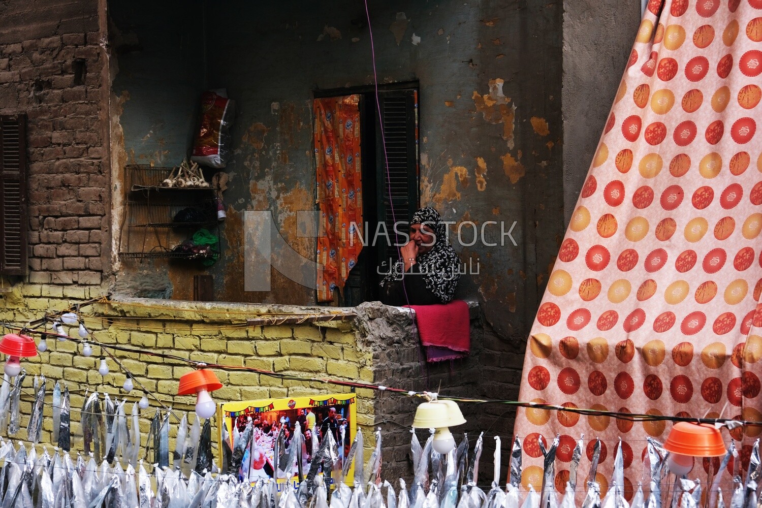 Old woman sitting on the balcony watching the preparing of the iftar, Ramadan Kareem, preparing their iftar