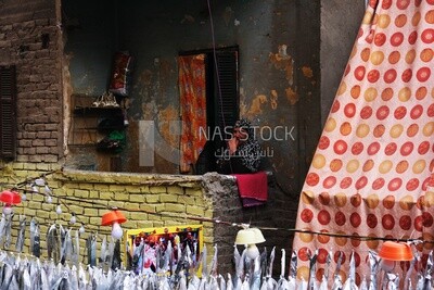 Old woman sitting on the balcony watching the preparing of the iftar, Ramadan Kareem, preparing their iftar