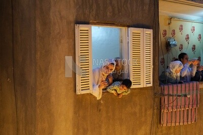 Women standing on the balcony watching the preparing of the iftar, Ramadan Kareem, preparing their iftar