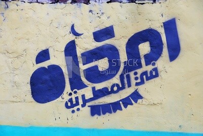 منظر للافتة المعلقة على الحائط في شارع المطرية وهم يتشاركون الإفطار معًا في الشارع ، رمضان كريم ، تحضير الإفطار