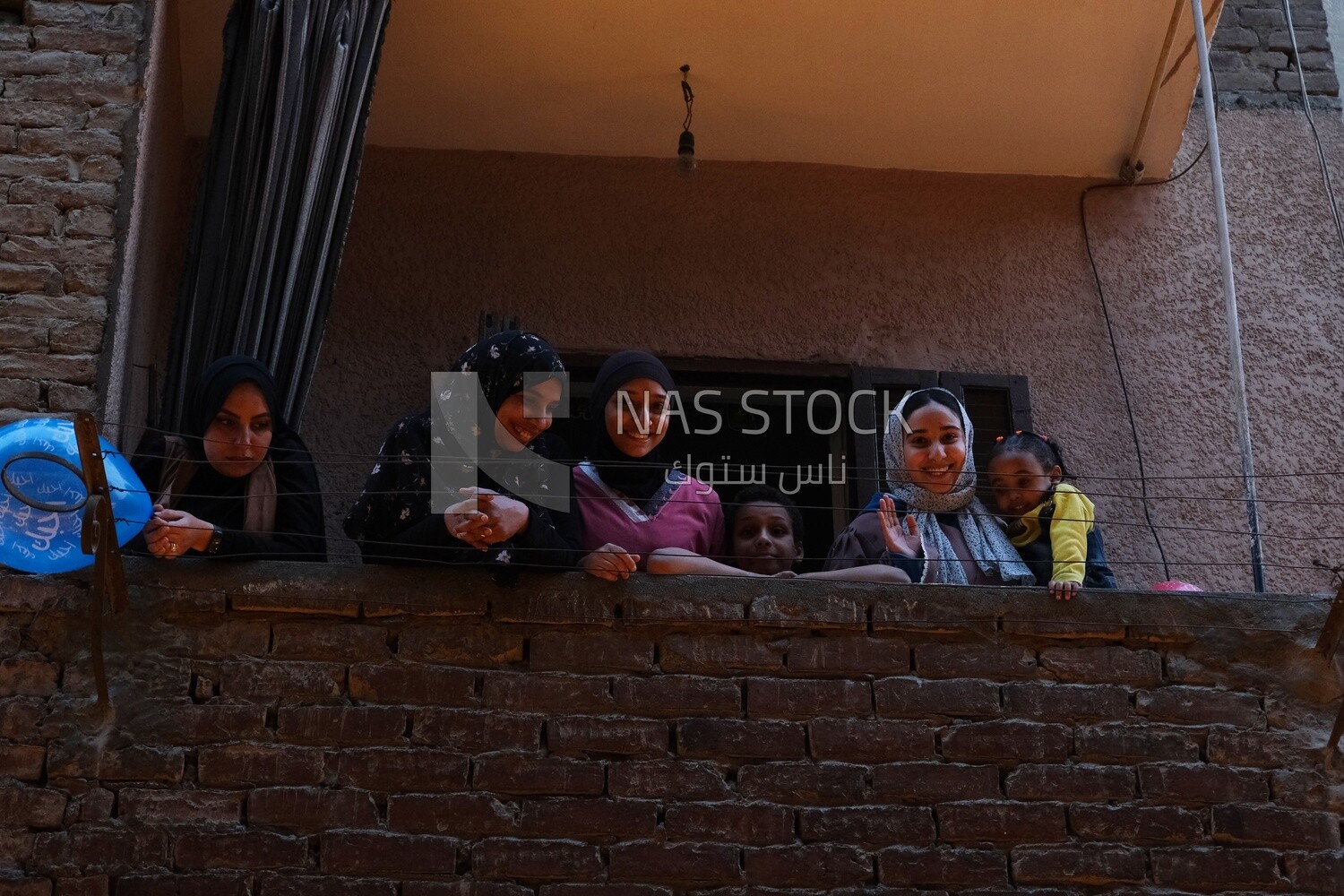 Women standing on the balcony watching the preparing of the iftar, Ramadan Kareem, preparing their iftar