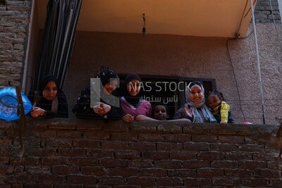 Women standing on the balcony watching the preparing of the iftar, Ramadan Kareem, preparing their iftar
