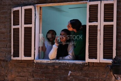 Girls standing on the balcony watching the preparing of the iftar, Ramadan Kareem, preparing their iftar