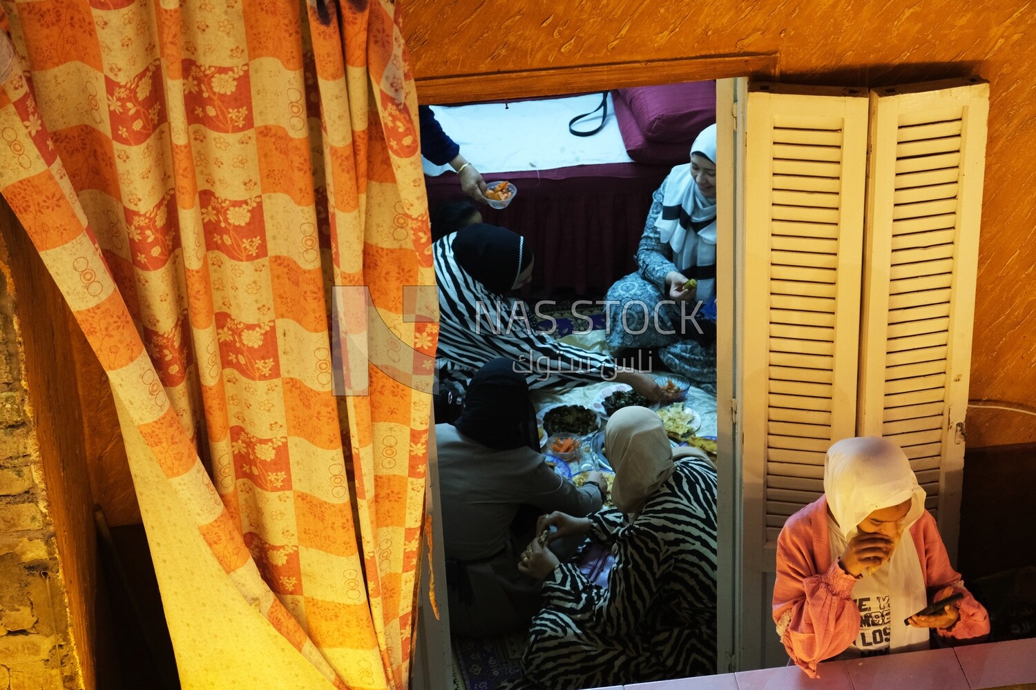 Women standing on the balcony watching the preparing of the iftar, Ramadan Kareem, preparing their iftar