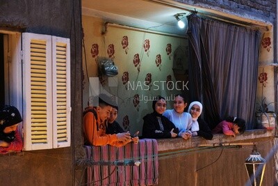 Women standing on the balcony watching the preparing of the iftar, Ramadan Kareem, preparing their iftar