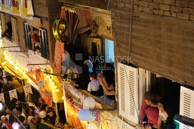 Women standing on the balcony watching the preparing of the iftar, Ramadan Kareem, preparing their iftar