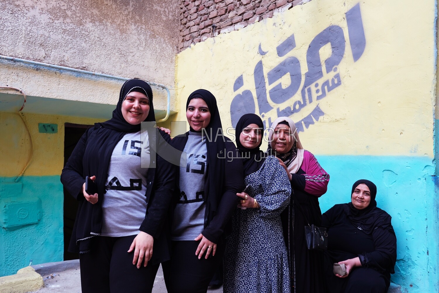 Women standing in the street taking a photo during the iftar on Matareya, Ramadan Kareem, preparing their iftar
