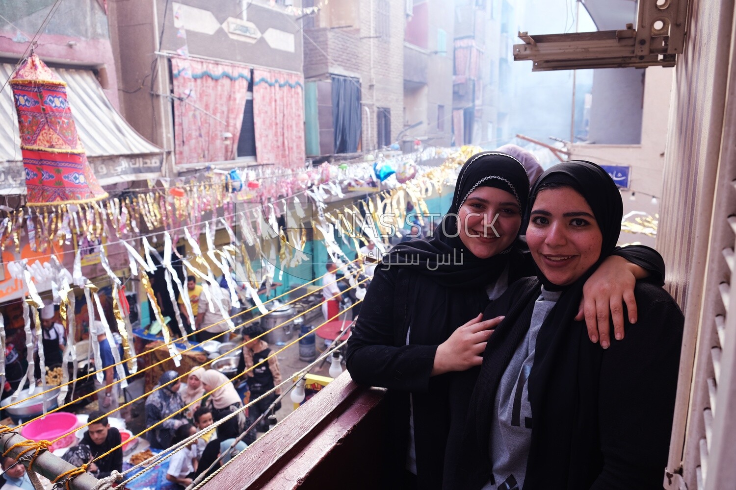 Women standing on the balcony taking a photo during preparing of the iftar, Ramadan Kareem, preparing their iftar