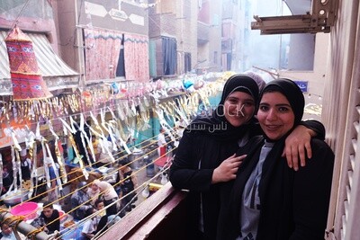 Women standing on the balcony taking a photo during preparing of the iftar, Ramadan Kareem, preparing their iftar