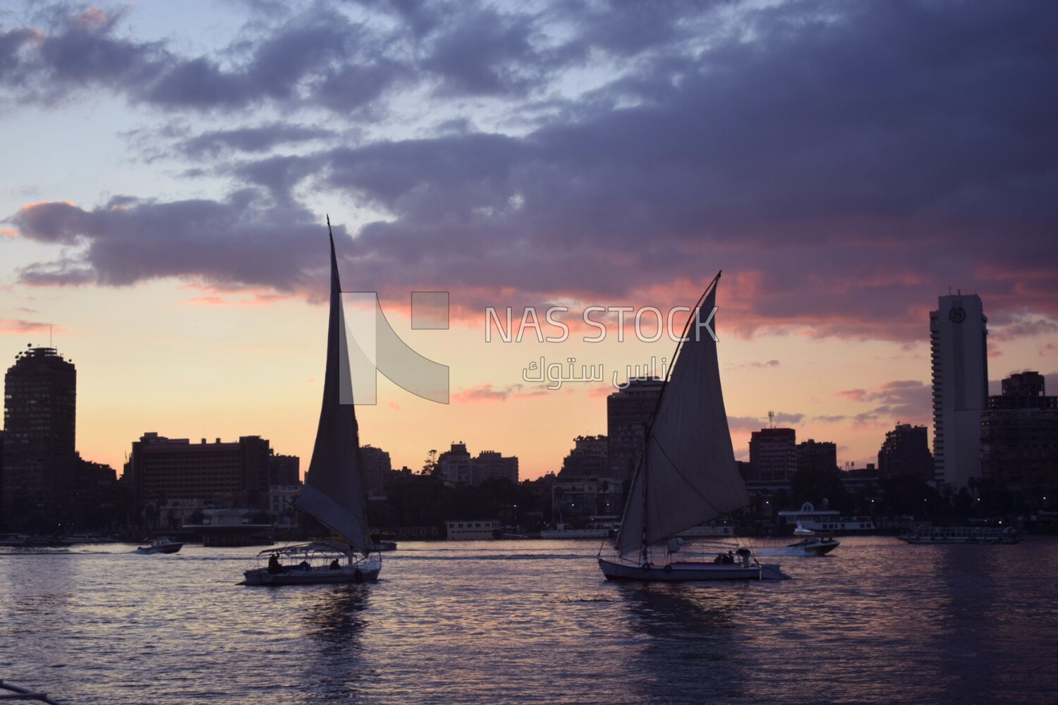 Picture showing sailboats taking a tour of the Nile River at sunset