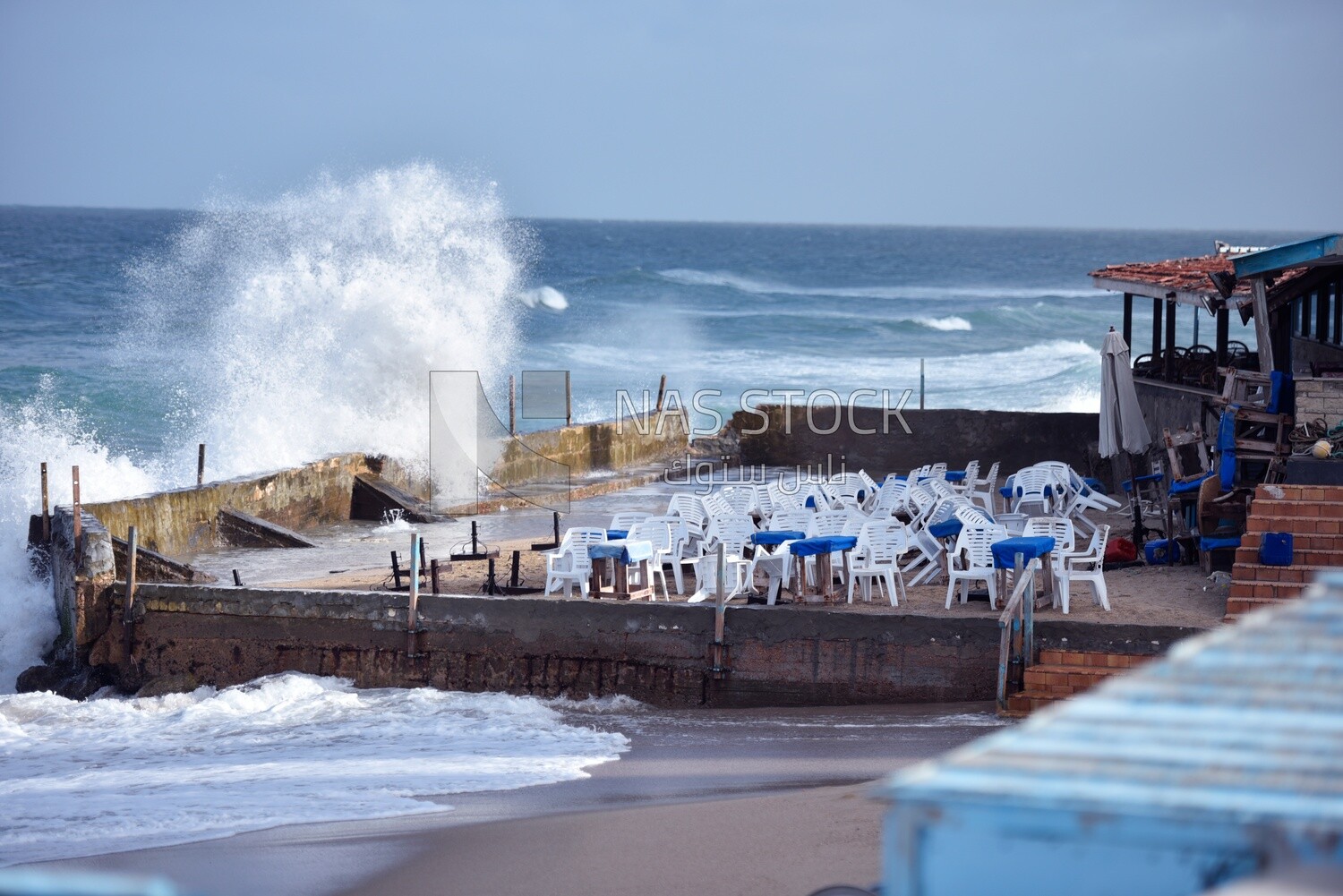 Sea waves hit the wall of a café