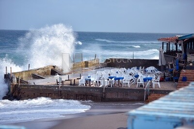 Sea waves hit the wall of a café