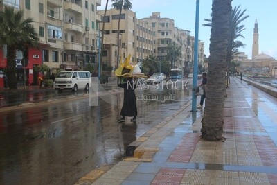 Man carrying a chair and crossing the road