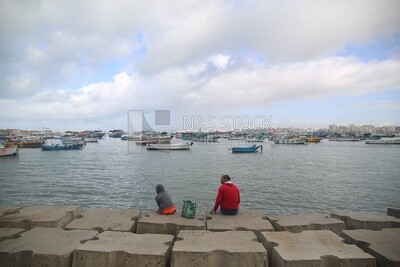 Man and his friend are sitting on the seashore