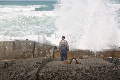 Young man stands on the seashore