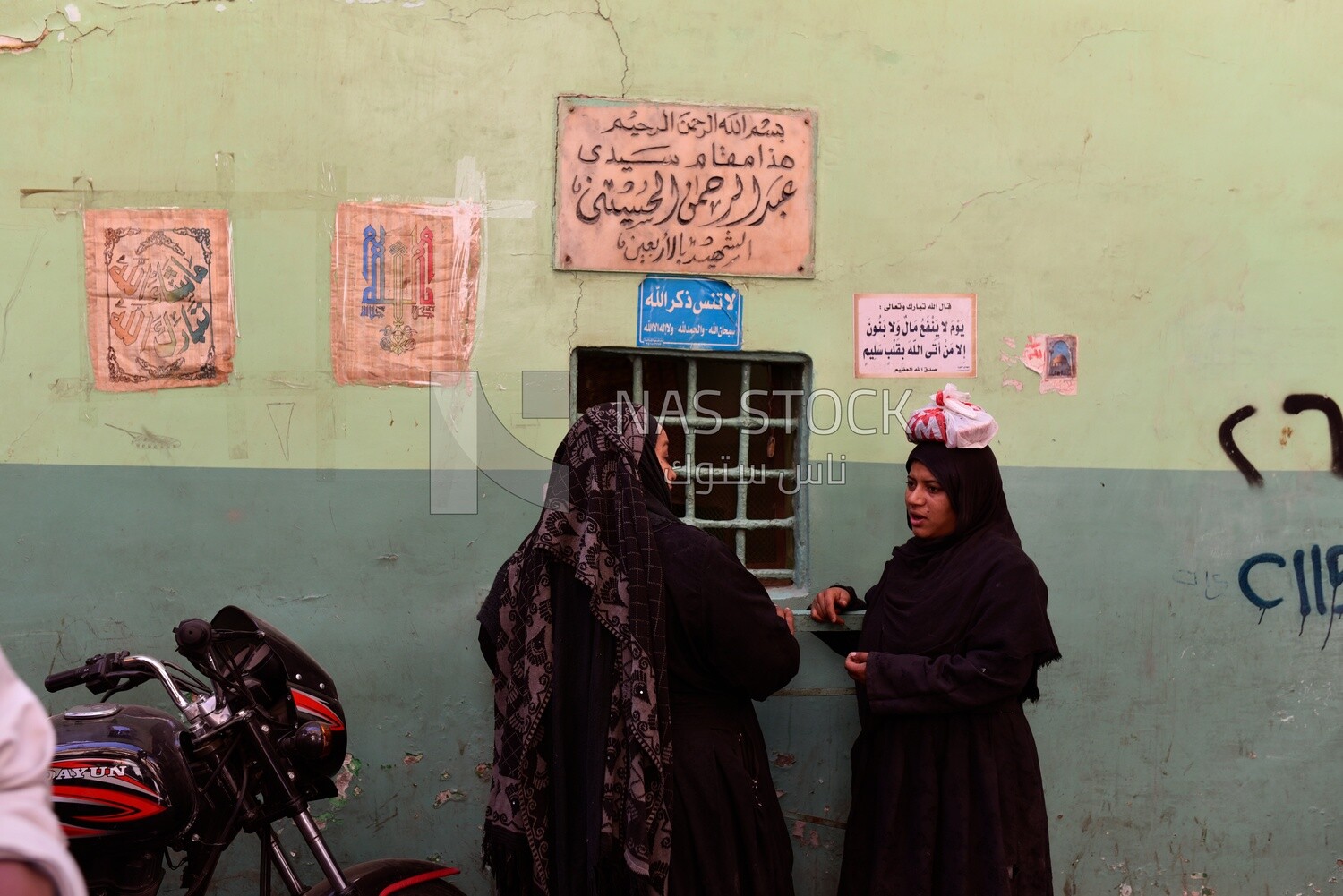 Two women stand at a shrine