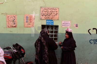 Two women stand at a shrine