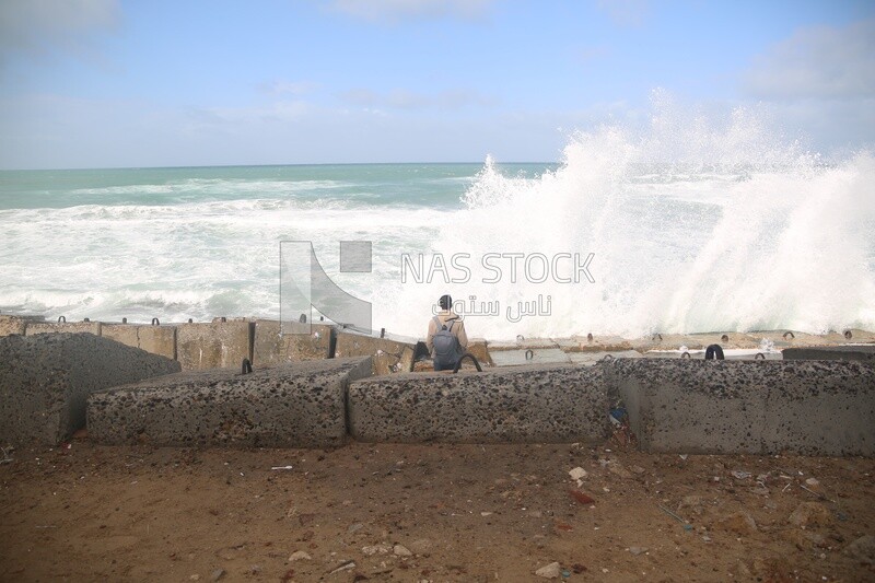 Young man stands on the seashore