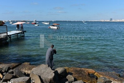 Man holding something he found on a rock in the sea