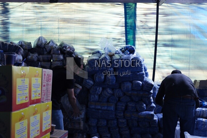 Two Egyptian men preparing bags of food for the poor