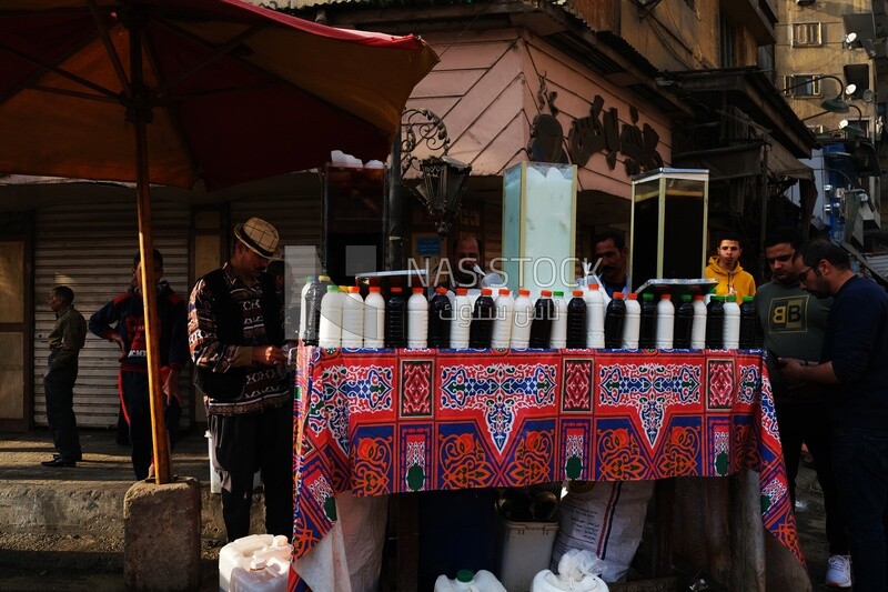 Man standing in front of a juice store, street, delicious drink, Ramadan Kareem