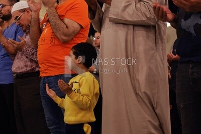Boy in the mosque, praying on the prayer rug, performing the obligatory prayer in the mosque, worship and draw close to God