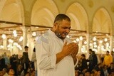 Man in the mosque, praying and crying to God, praying on the prayer rug, performing the obligatory prayer in the mosque, worship and draw close to God