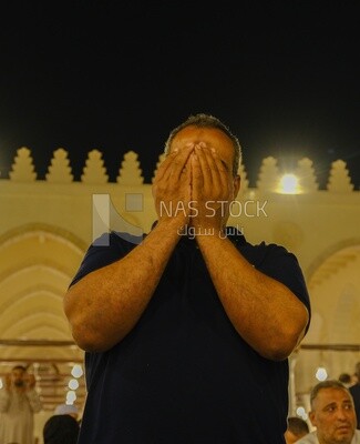 Man in the mosque, praying and crying to God, praying on the prayer rug, performing the obligatory prayer in the mosque, worship and draw close to God