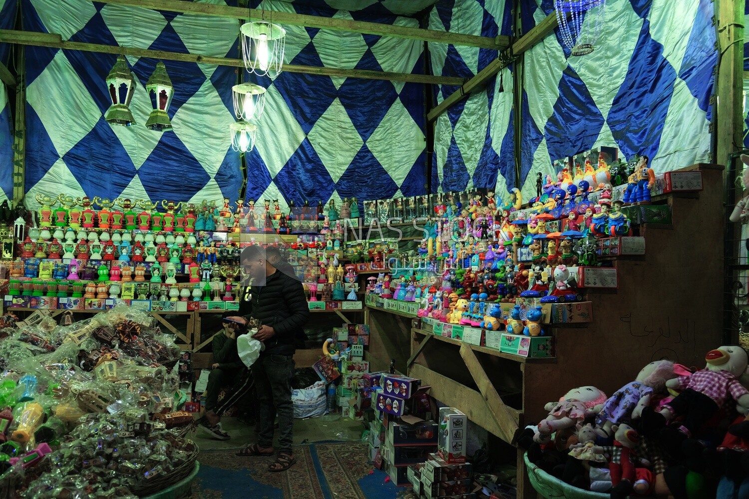 People in a street shop selling lanterns, Hanging lanterns, Sayeda Zainab and Ramadan Kareem.