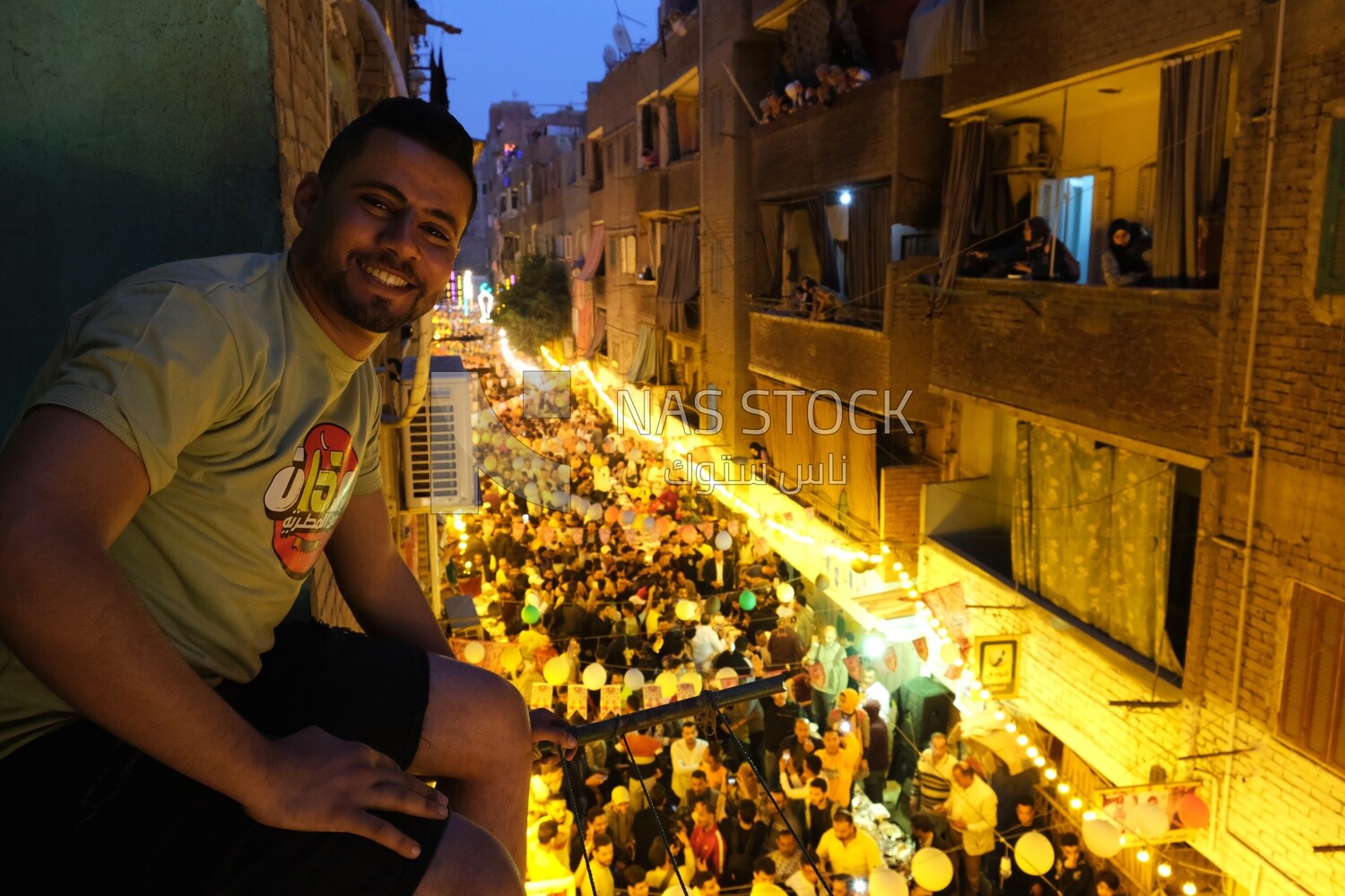 Man sitting on the Balcony wall watching the iftar in  Matareya, Ramadan Kareem, preparing their iftar, sharing their iftar