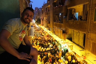 Man sitting on the Balcony wall watching the iftar in  Matareya, Ramadan Kareem, preparing their iftar, sharing their iftar