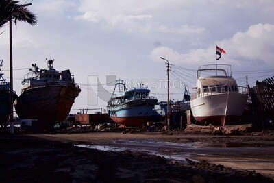 Four yachts are standing on the shore for maintenance work