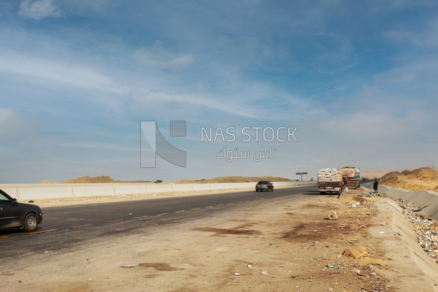 Picture of the desert road and some transport trucks parked on the road