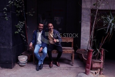 Two friends sitting happily smiling in front of the camera