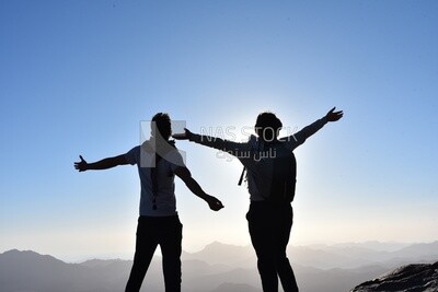 Couples celebrate together reaching the top of the mountain