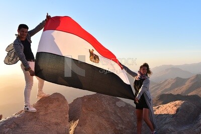 Tourists raise the Egyptian flag on the top of a mountain in Sinai,Egypt