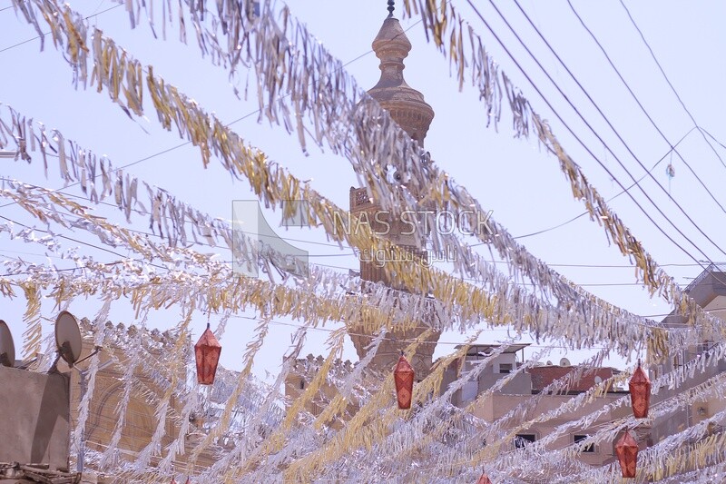 View of a street full of decorations and hanging lanterns in the middle, Ramadan vibes