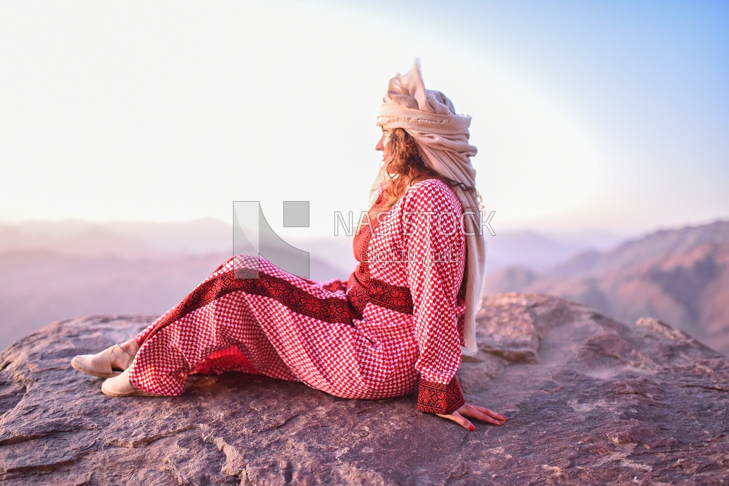 European girl wearing Bedouin dress and enjoying the sunset