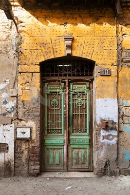 Old green decorated painted door on yellow painted stone wall, Old Cairo, Egypt