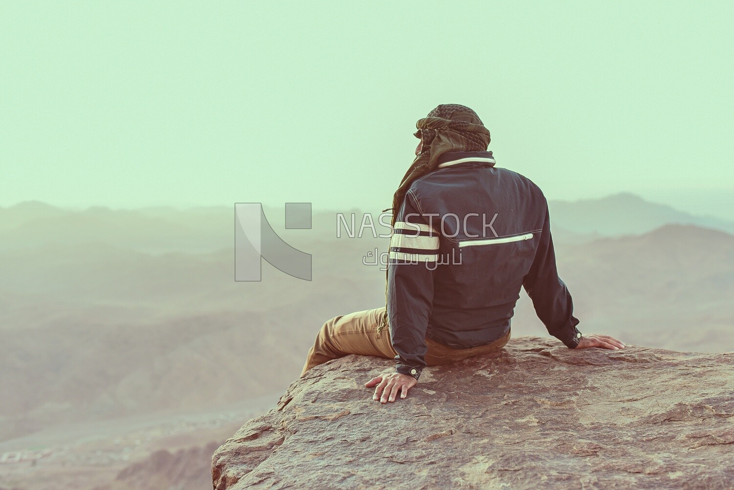 Traveler sitting on the edge of a cliff