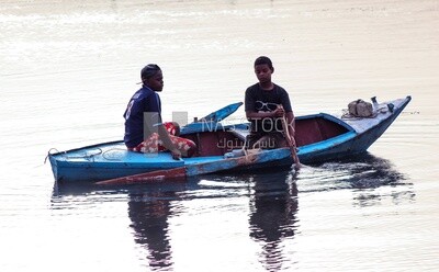 Two children riding a wooden boat ,Aswan, Egypt