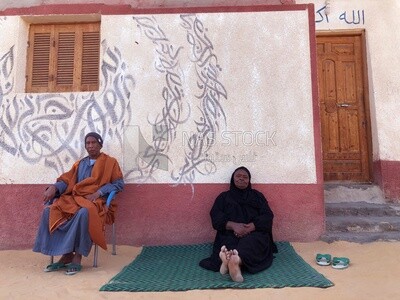 woman sits with her husband in front of the house, Aswan,Egypt