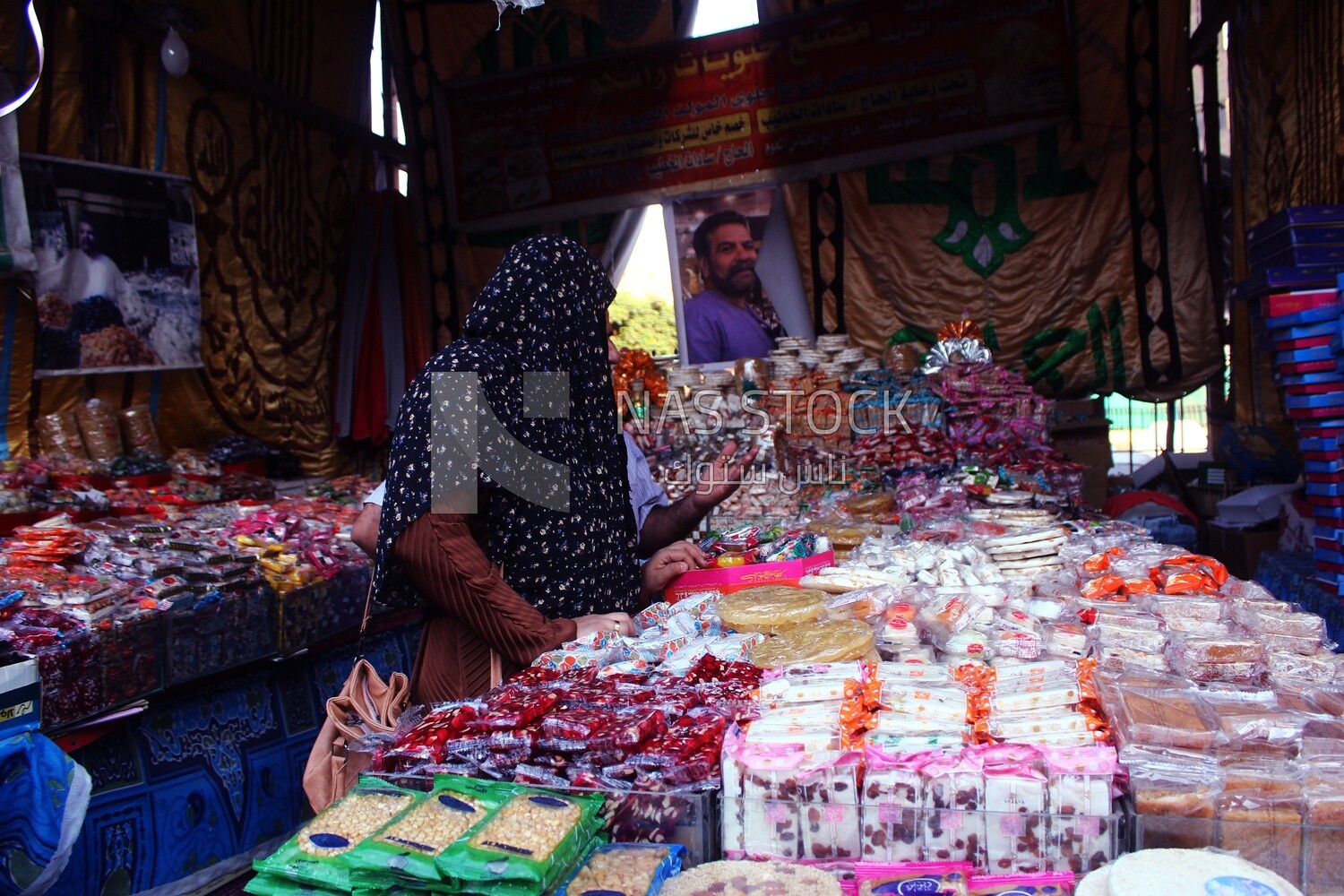 Woman puts the candies of the prophet Muhammad&#39;s birth on the box