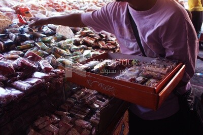 Man puts the candies of the prophet Muhammad&#39;s birth on the box