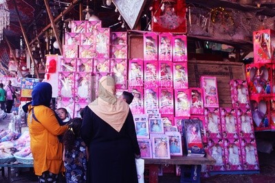 Woman with her children standing buying the Mawlid dolls in the street, Egyptian Desserts of Prophet Muhammad&#39;s Birth Celebration