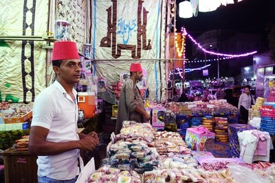 رجل يقف يبيع حلوى مولد النبي محمد في الشارع