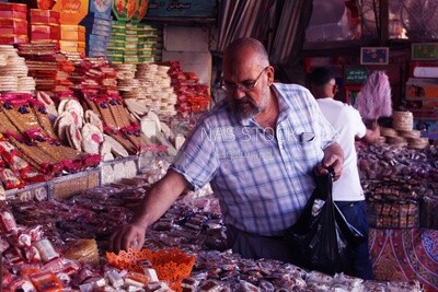 Man puts the candies of the prophet Muhammad&#39;s birth on the box