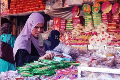 Woman puts the candies of the prophet Muhammad&#39;s birth on the box