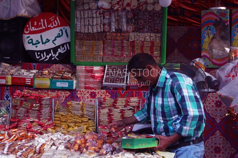 Man puts the candies of the prophet Muhammad&#39;s birth on the box