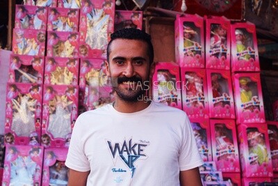 Close up of man standing in front of the Mawlid dolls in the street, Egyptian Desserts of Prophet Muhammad&#39;s Birth Celebration